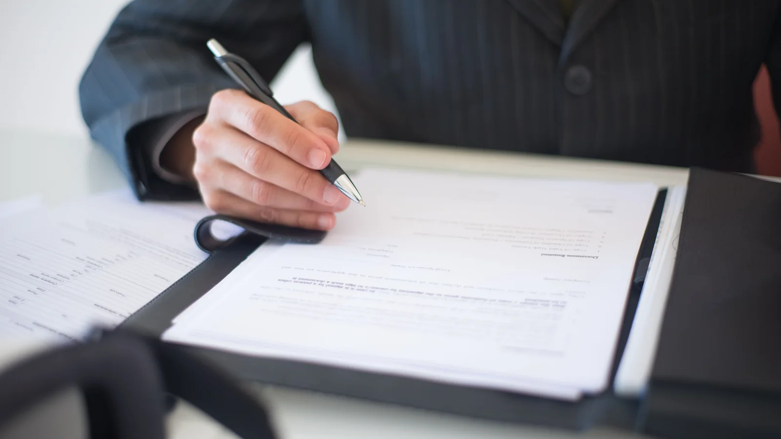 Person signing a document to represent filling and signing a PDF online
