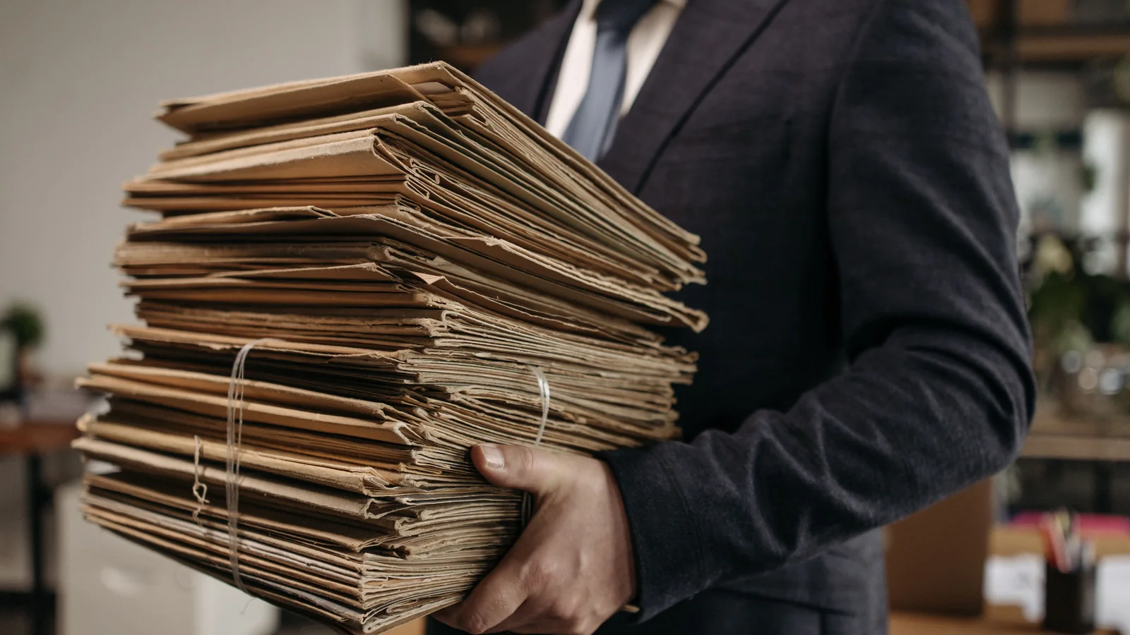 Professional carrying multiple document folders to represent merging PDF files