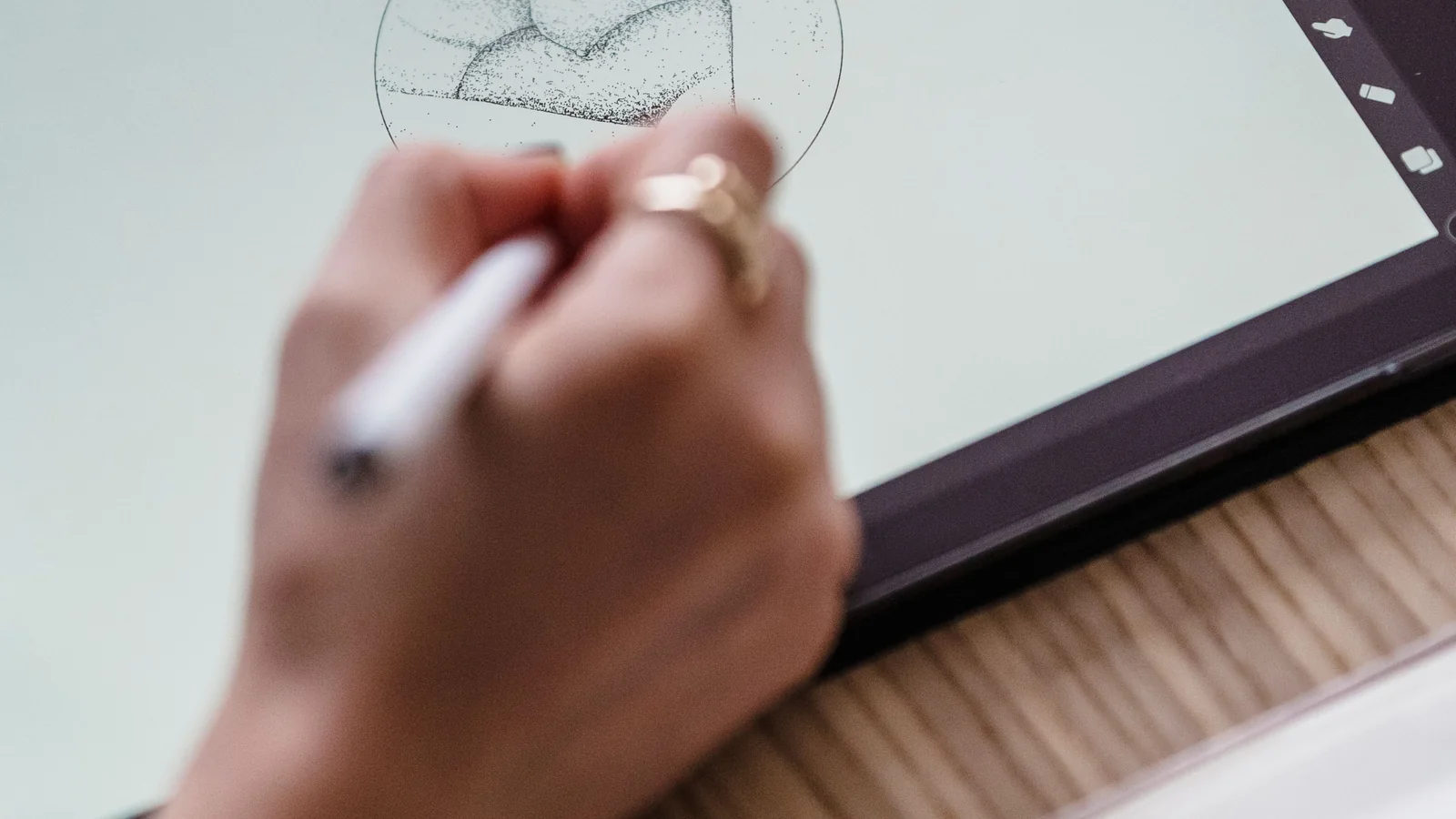 Designer sketching a small logo icon on a digital tablet for a favicon